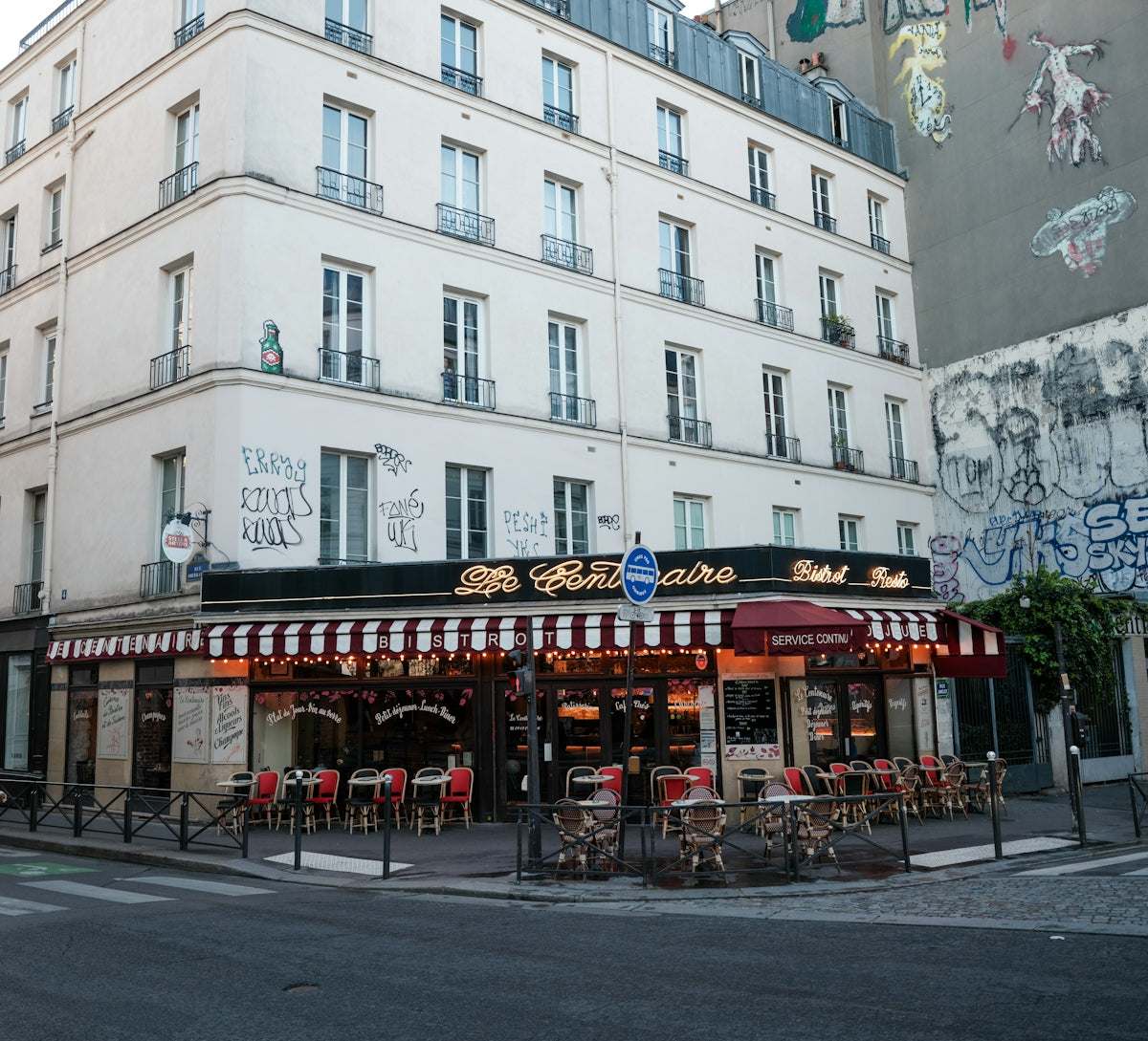 Corner cafe with outdoor seating and striped awning